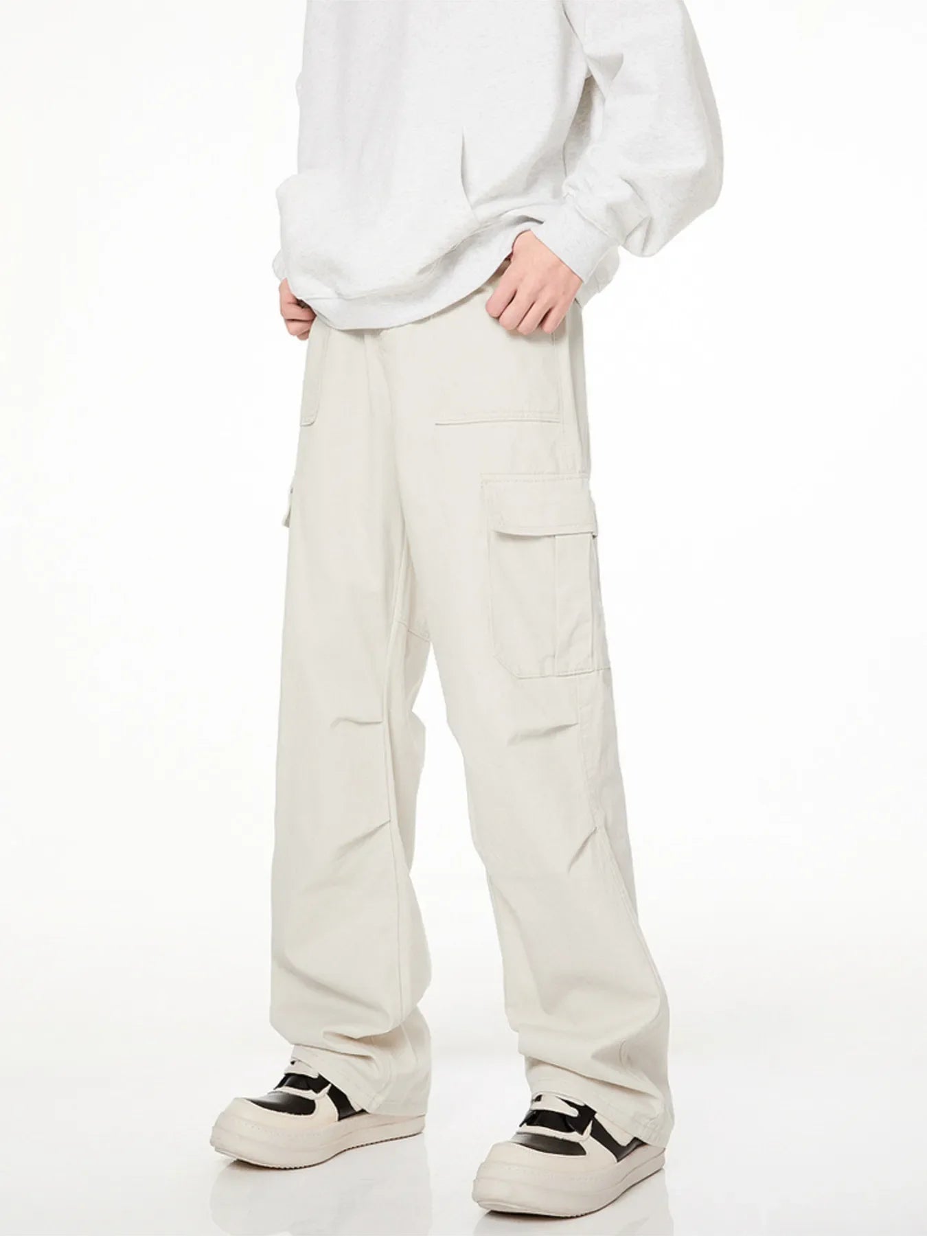 Men's loose fit cargo pants in creamy-white with multiple pockets.
