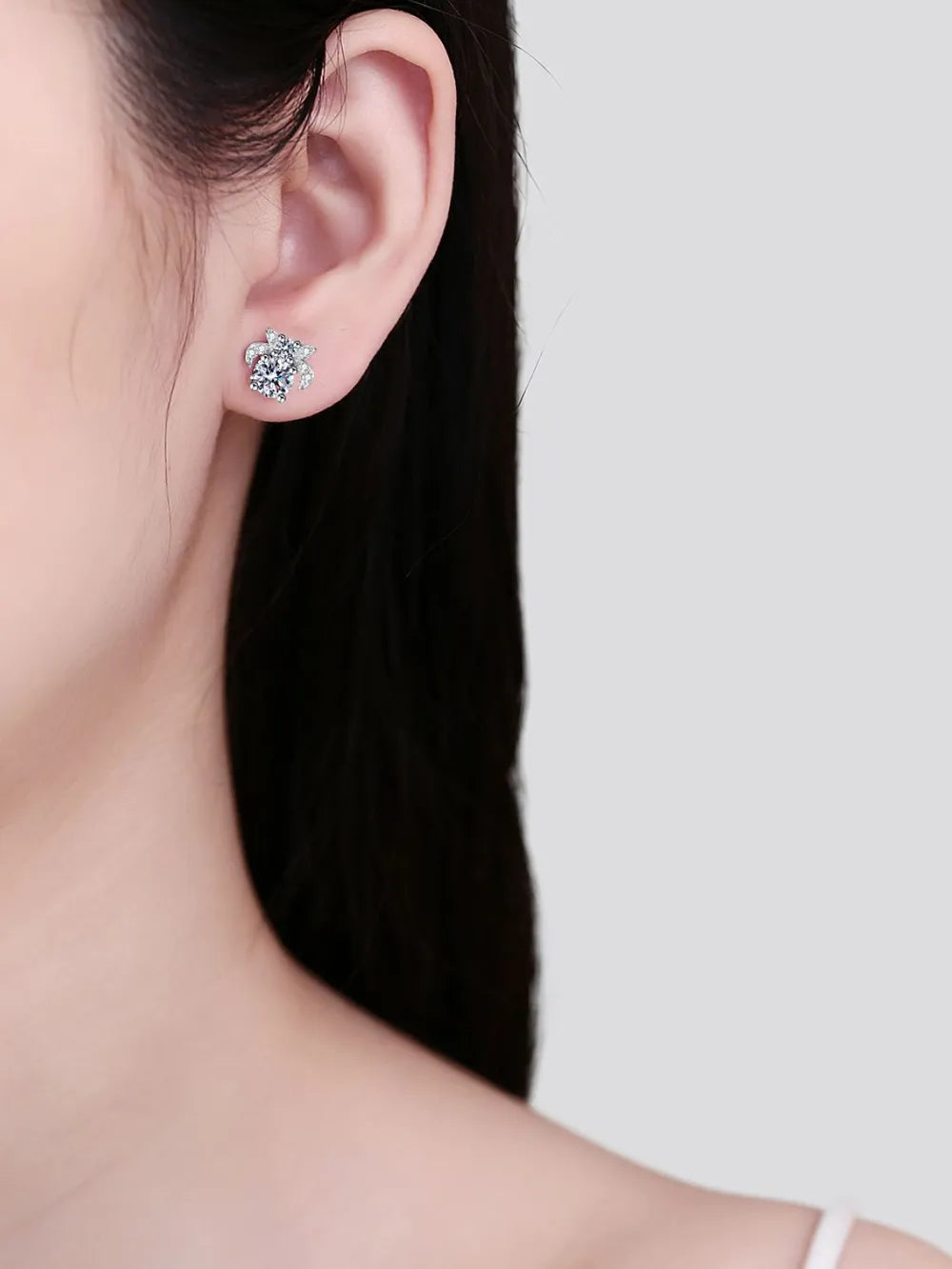 Silver moissanite floral cluster stud earrings with sparkling stones.