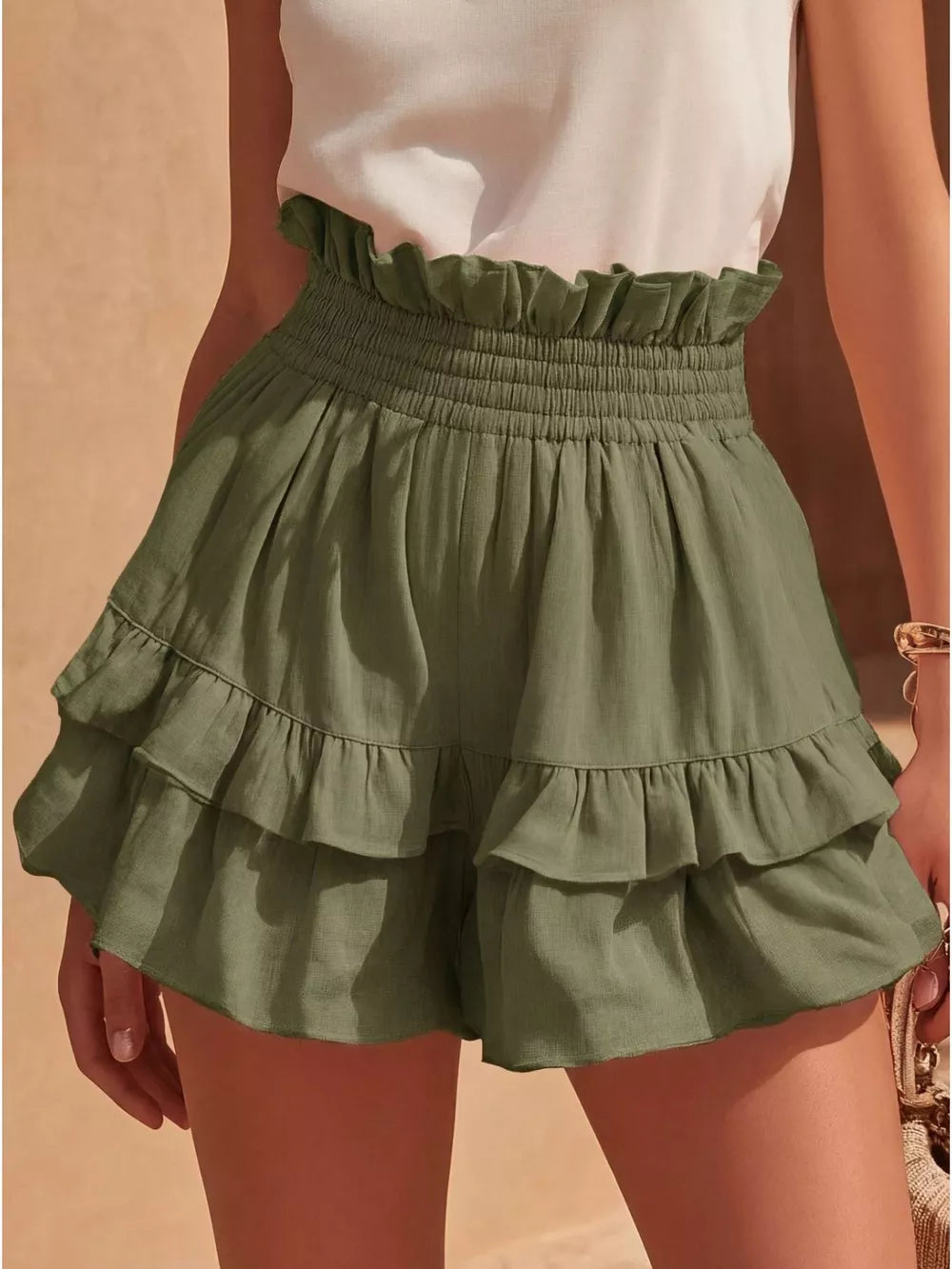 Army green ruffled high-waisted shorts with smocked waistband and tiered hem.