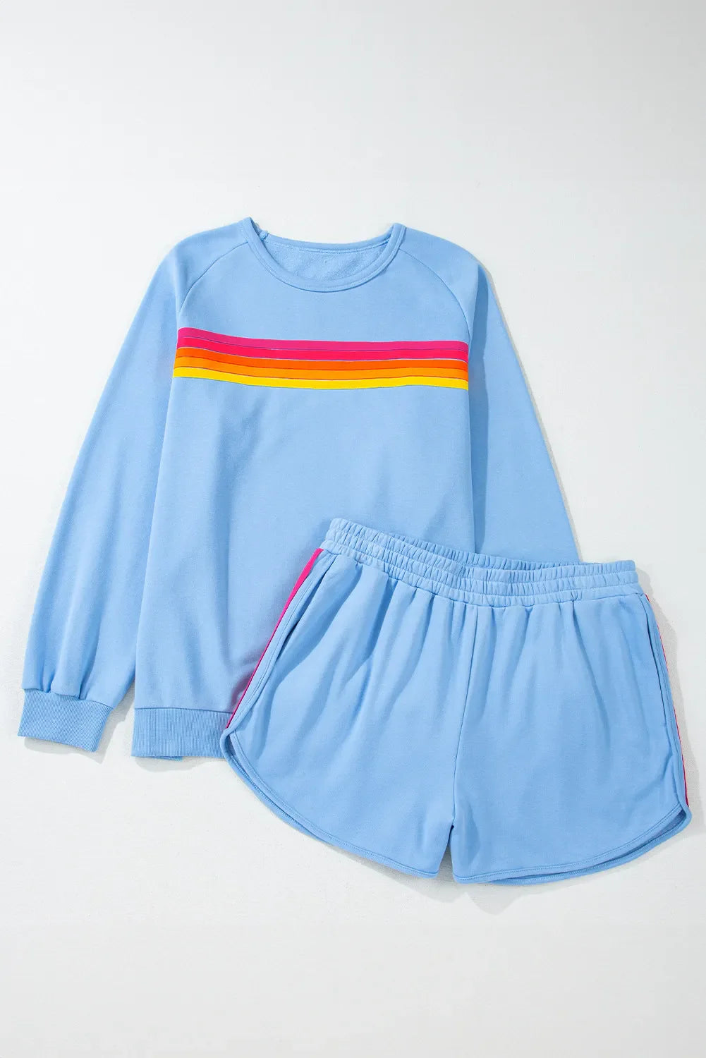 Pastel blue loungewear set with rainbow stripe detail on sweatshirt and shorts.