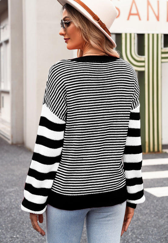 Black and white striped knit sweater with a crew neck and long sleeves.