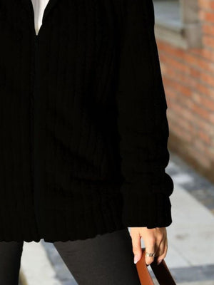 Black ribbed zip-up jacket with a collared neckline and textured fabric.