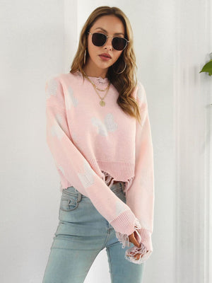 Blush pink distressed knit cropped sweater with white butterfly print and frayed hem.