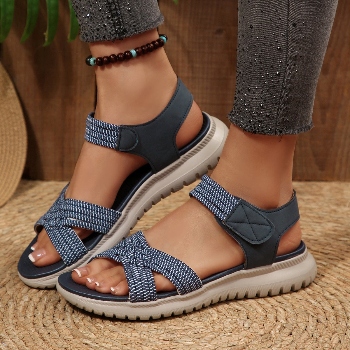 Blue woven strap open-toe flat sandals with adjustable ankle strap and cushioned sole.