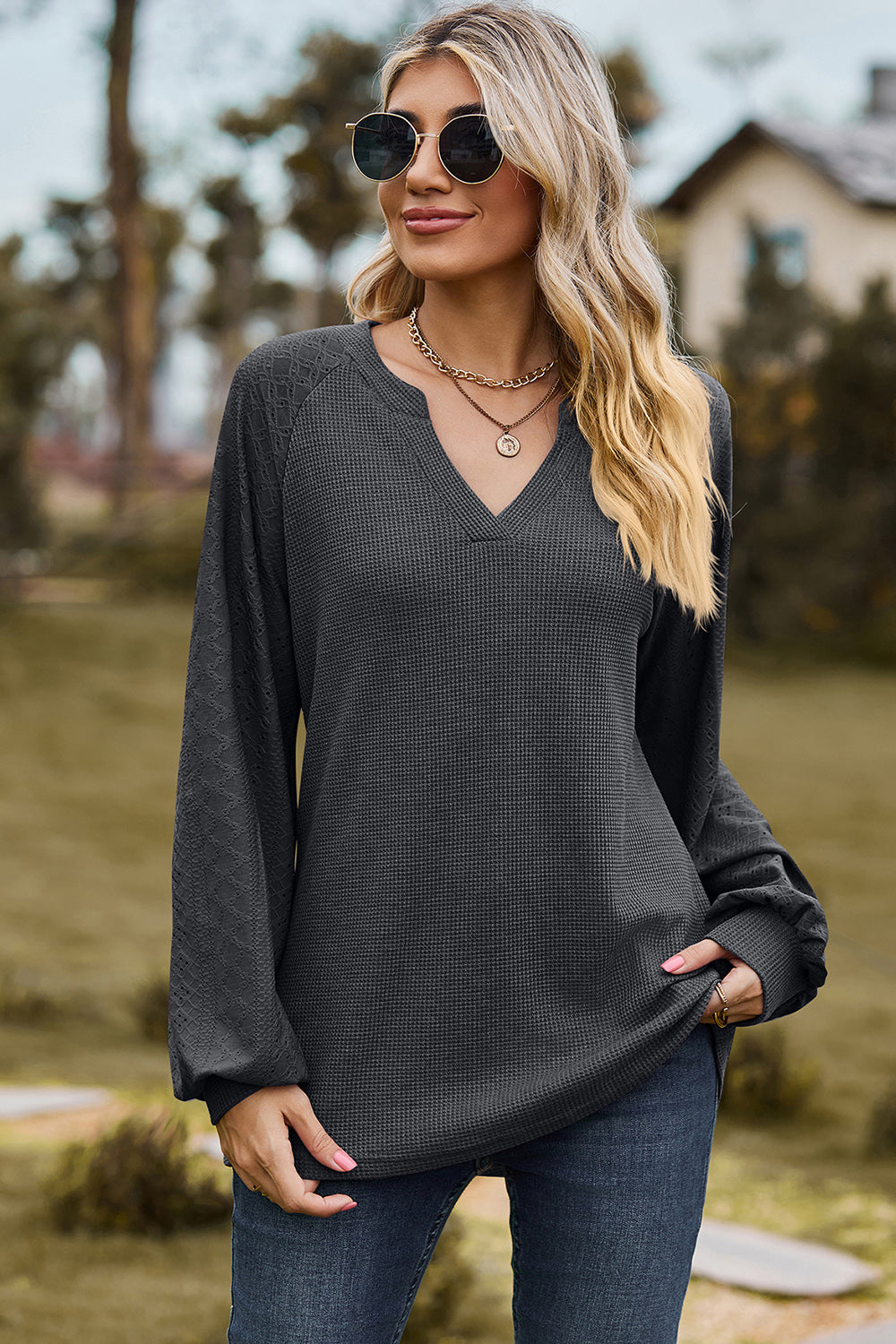 Dark Gray waffle knit raglan v-neck top with textured sleeves and a relaxed fit.