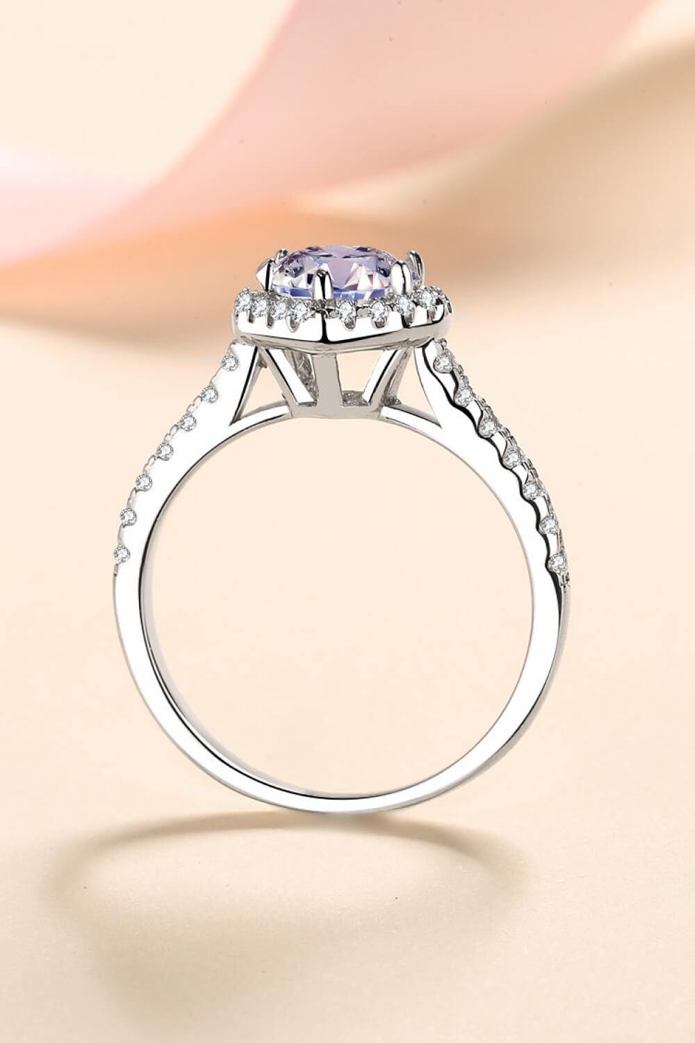 Silver ring with a heart-cut diamond halo and pavé band.