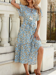 Blue daisy print midi dress with tie front, short sleeves, and tiered hem.