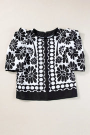 Black floral puff sleeve blouse with button back and pom-pom trim.