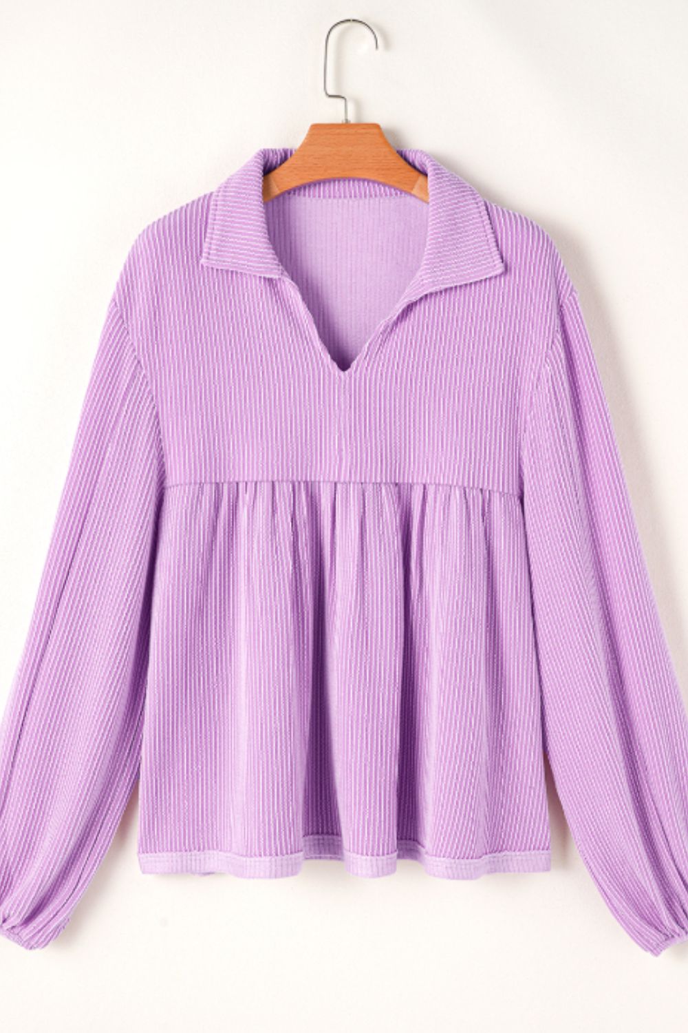 Lilac textured blouse with gathered yoke, collar, and long sleeves.