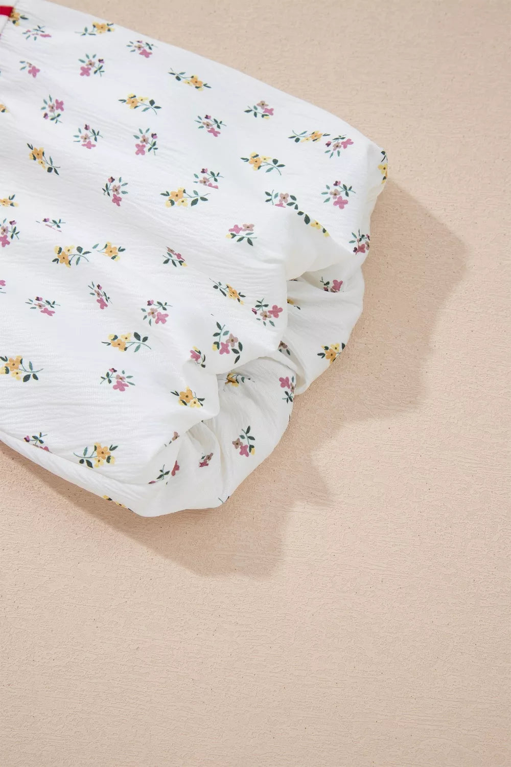 White cotton maternity shirt with a playful floral print and puff sleeves.