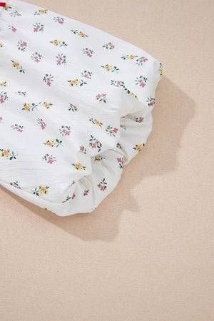 White cotton maternity shirt with a playful floral print and puff sleeves.