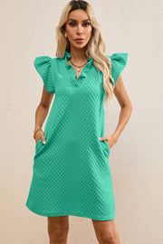 Turquoise trapeze dress with textured fabric, ruffle sleeves, V-neck, and pockets.