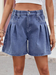 Pleated denim culotte shorts in dusty blue with a buttoned fly and elastic waistband.