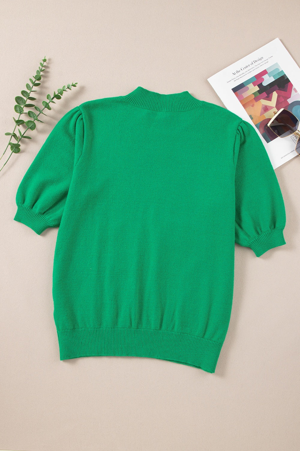 Green knit sweater with mock neck and puff sleeves.