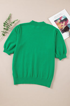 Green knit sweater with mock neck and puff sleeves.