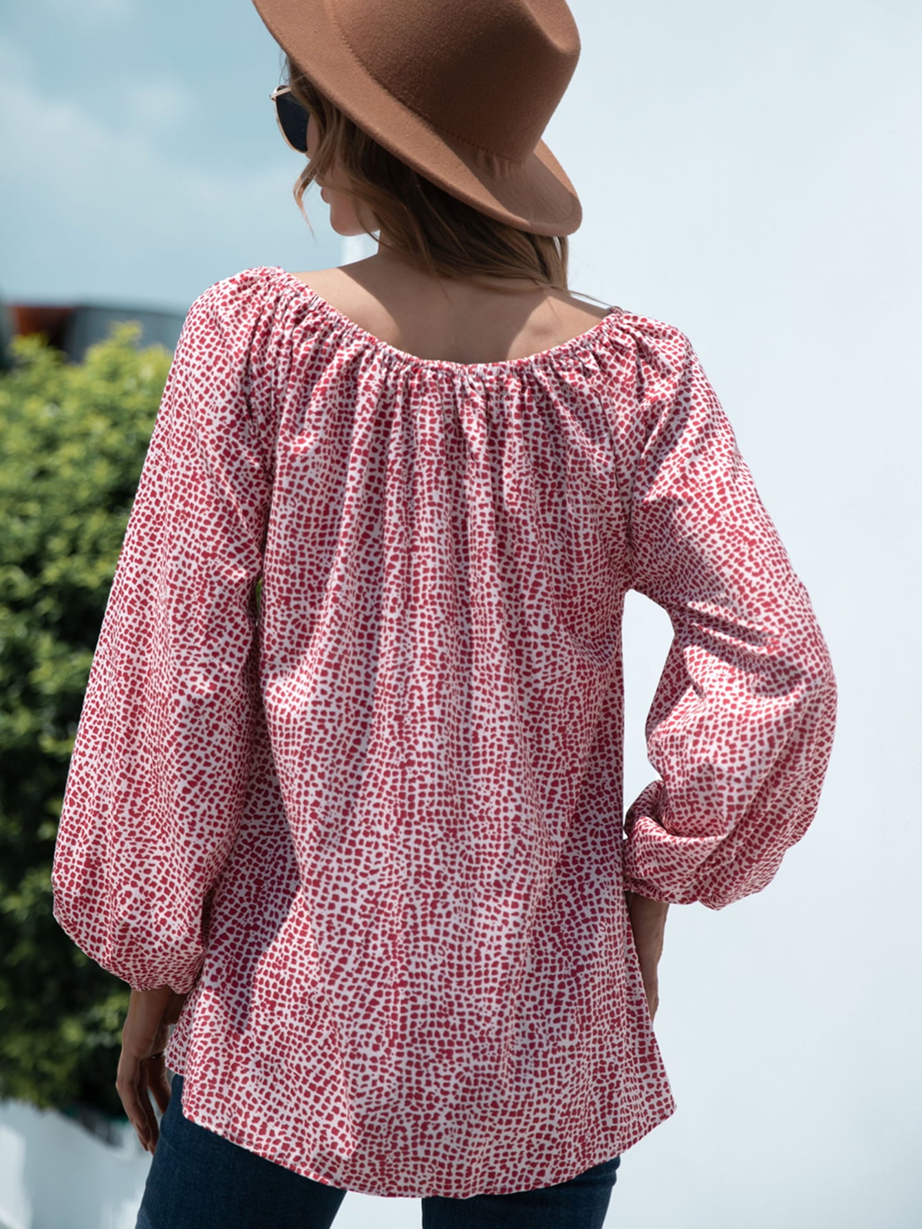 Off-the-shoulder red spotted print blouson top with balloon sleeves.
