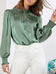 Romantic tie-neck blouse in Gum Leaf satin with shirred cuffs and puff sleeves.