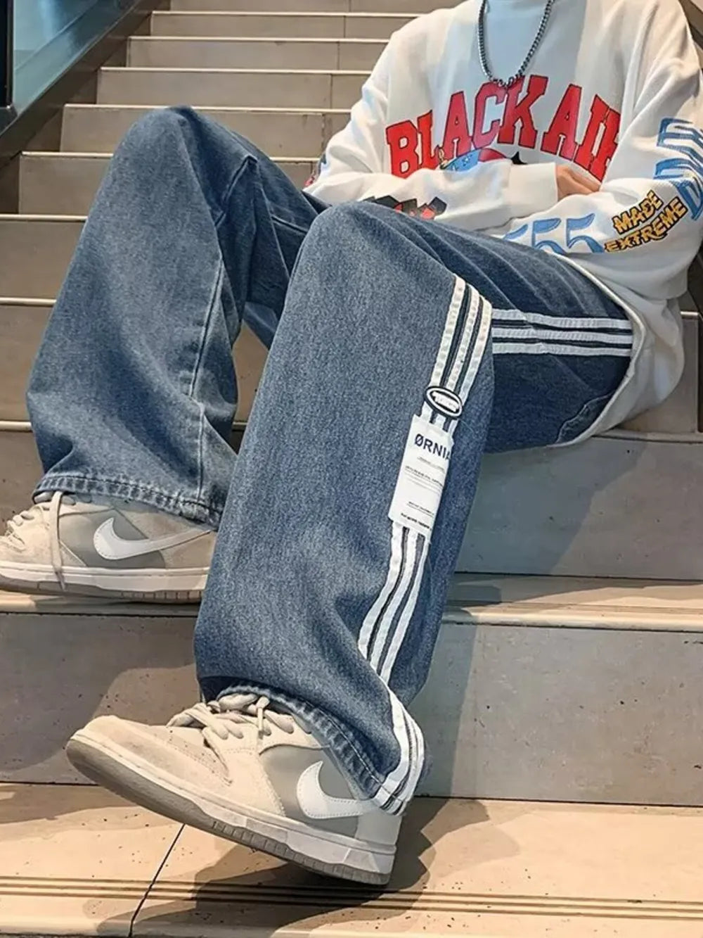 Men's blue oversized wide-leg jeans with white side stripes and a casual fit.