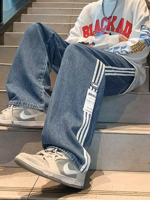 Men's blue oversized wide-leg jeans with white side stripes and a casual fit.