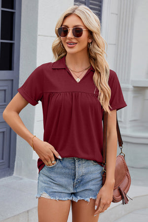 Burgundy polo top with gathered yoke and cuffed short sleeves.