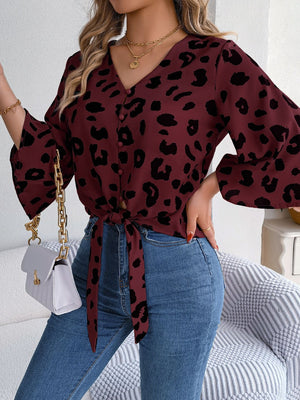 Burgundy leopard print tie-front blouse with button detail and bell sleeves.