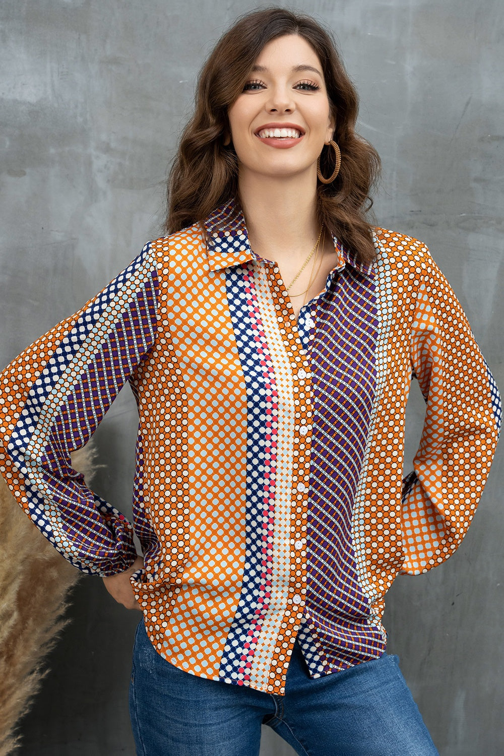 Geometric print blouson sleeve blouse in orange with blue and white polka dots and stripes.