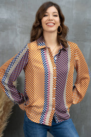 Geometric print blouson sleeve blouse in orange with blue and white polka dots and stripes.