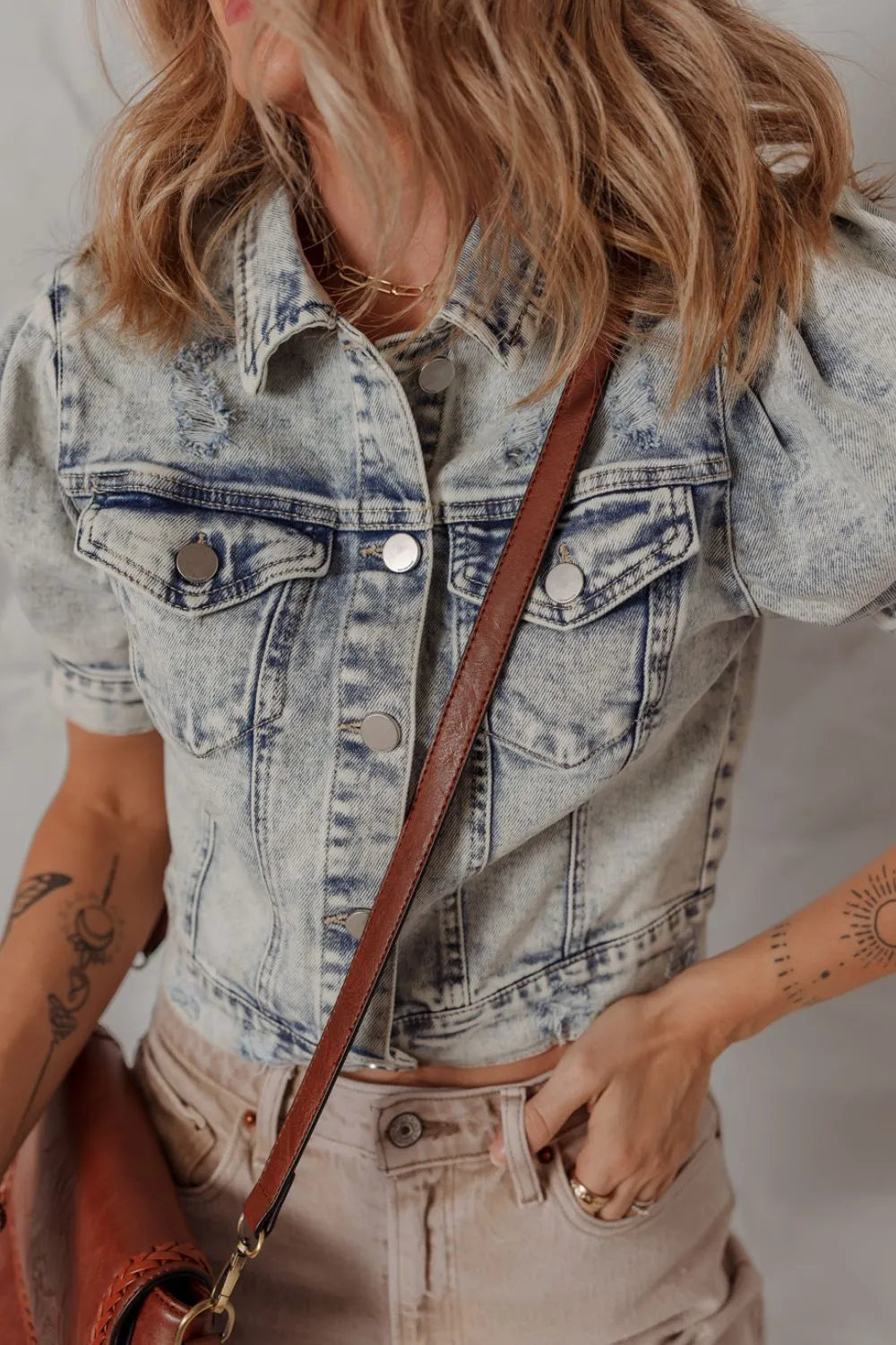 Cropped denim bolero jacket in medium wash with puff sleeves and distressed details.