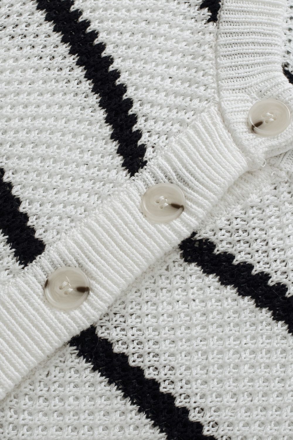 White and black stripe knit pullover sweater with button detail.