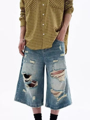 Distressed blue denim wide-leg shorts for men with ripped details.