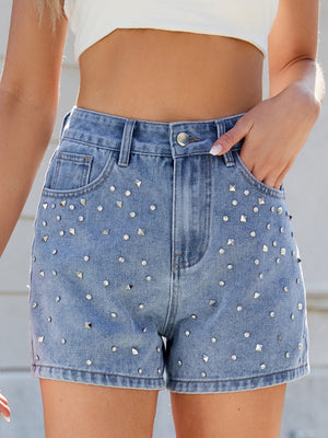 Medium wash denim shorts with allover silver studs and rhinestones, high-waisted cutoff style