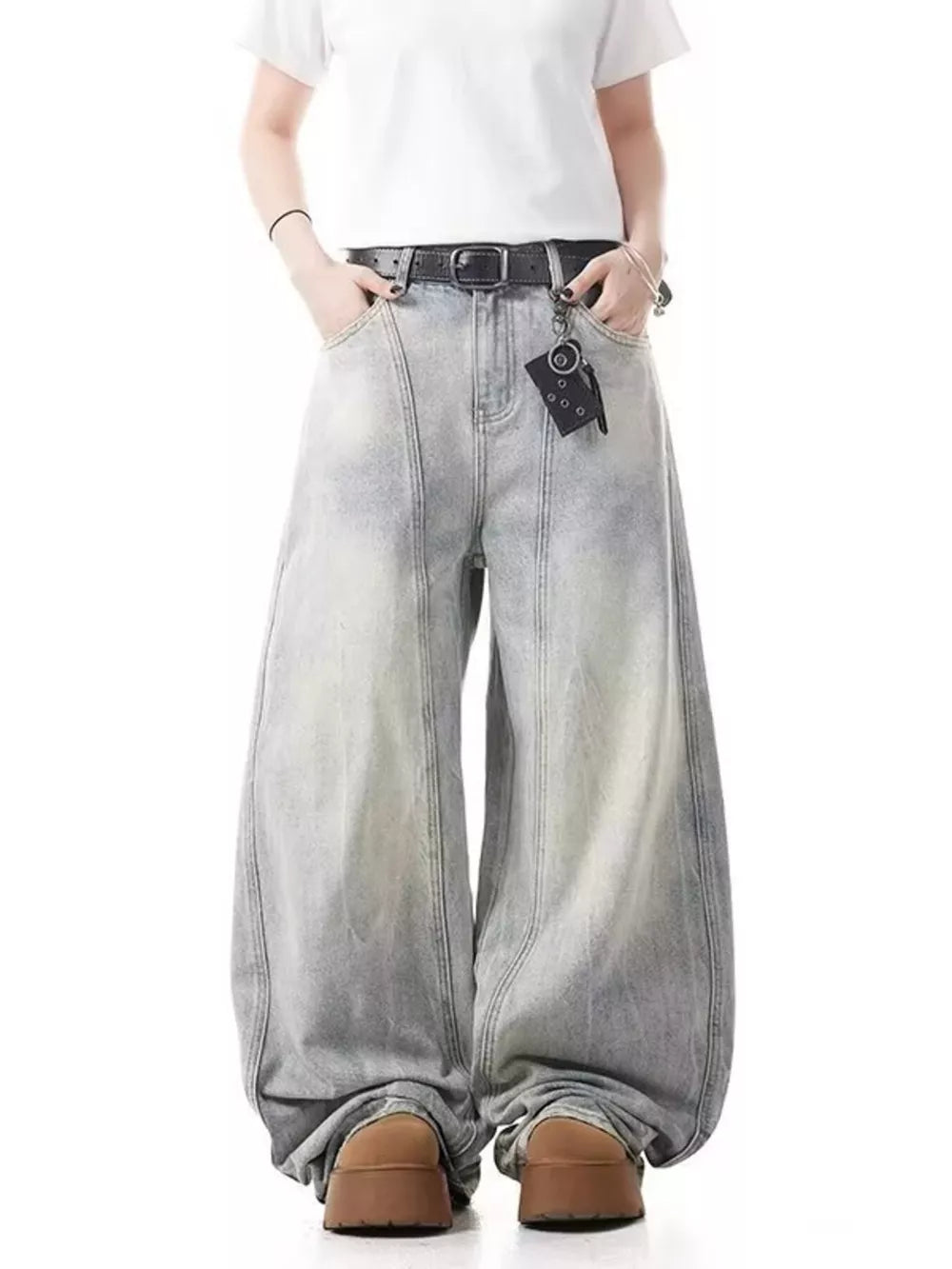 Baggy light wash denim jeans with a belted waist and wide leg.