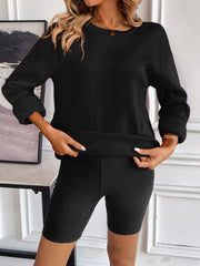 Black relaxed fit sweatshirt with crew neck and cuffed sleeves, shown with matching shorts.