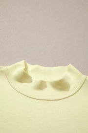 Yellow mock neck top with visible stitching detail