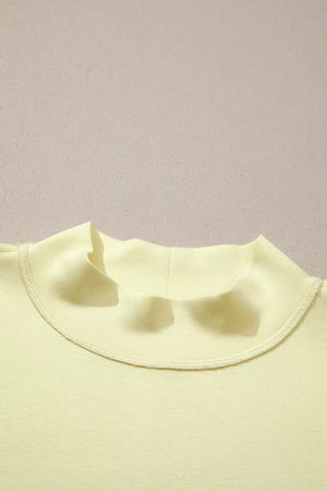 Yellow mock neck top with visible stitching detail