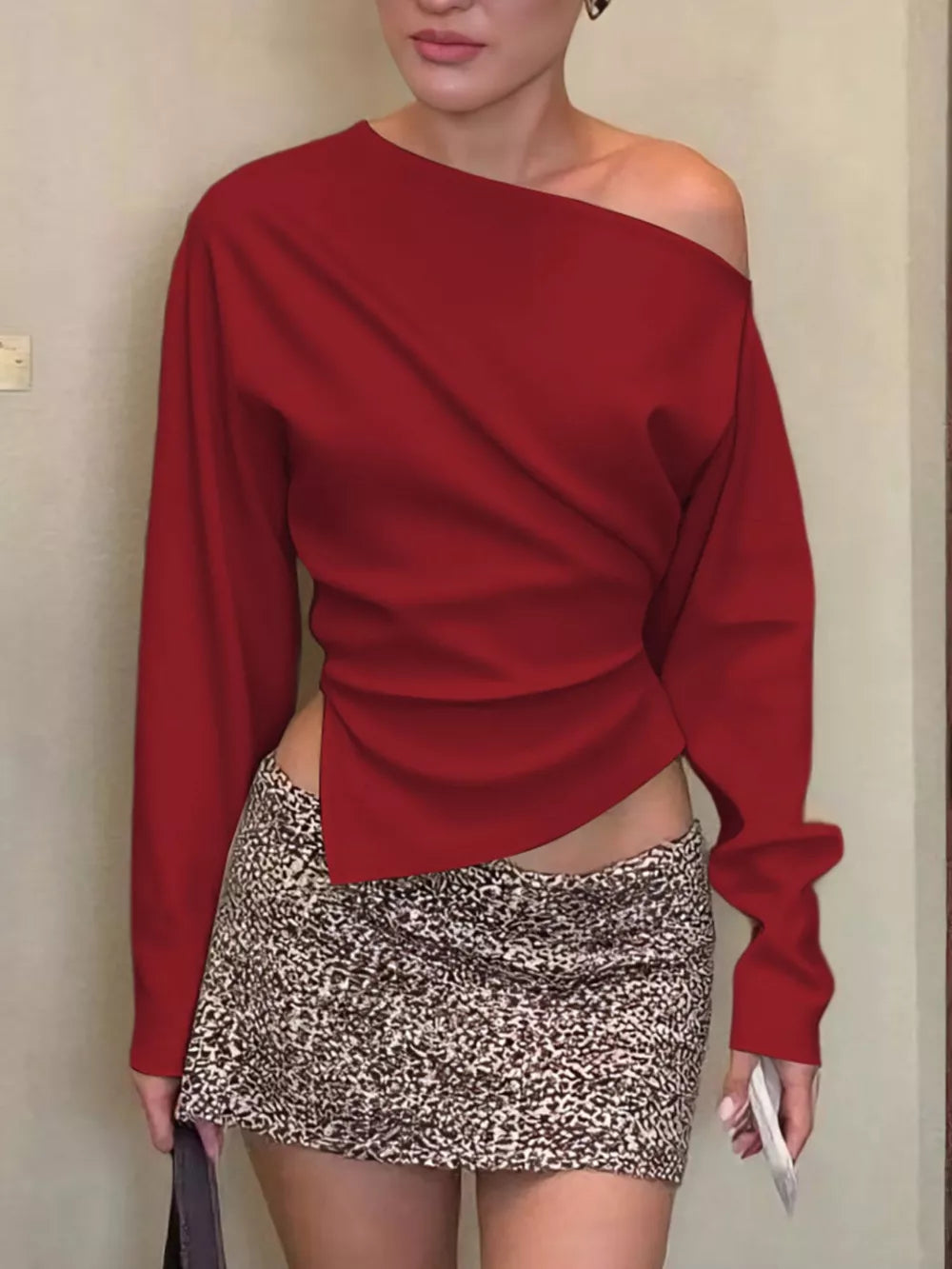 Red draped asymmetrical off-shoulder t-shirt with long sleeves and a unique cut.
