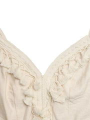 Cream lace-trimmed spaghetti strap romper with tassel details at V-neck.