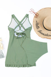 Sage ruched halter swim dress with crisscross back tie and ruffled hem.