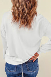 White crewneck sweatshirt with long sleeves, casual fit, paired with blue jeans.