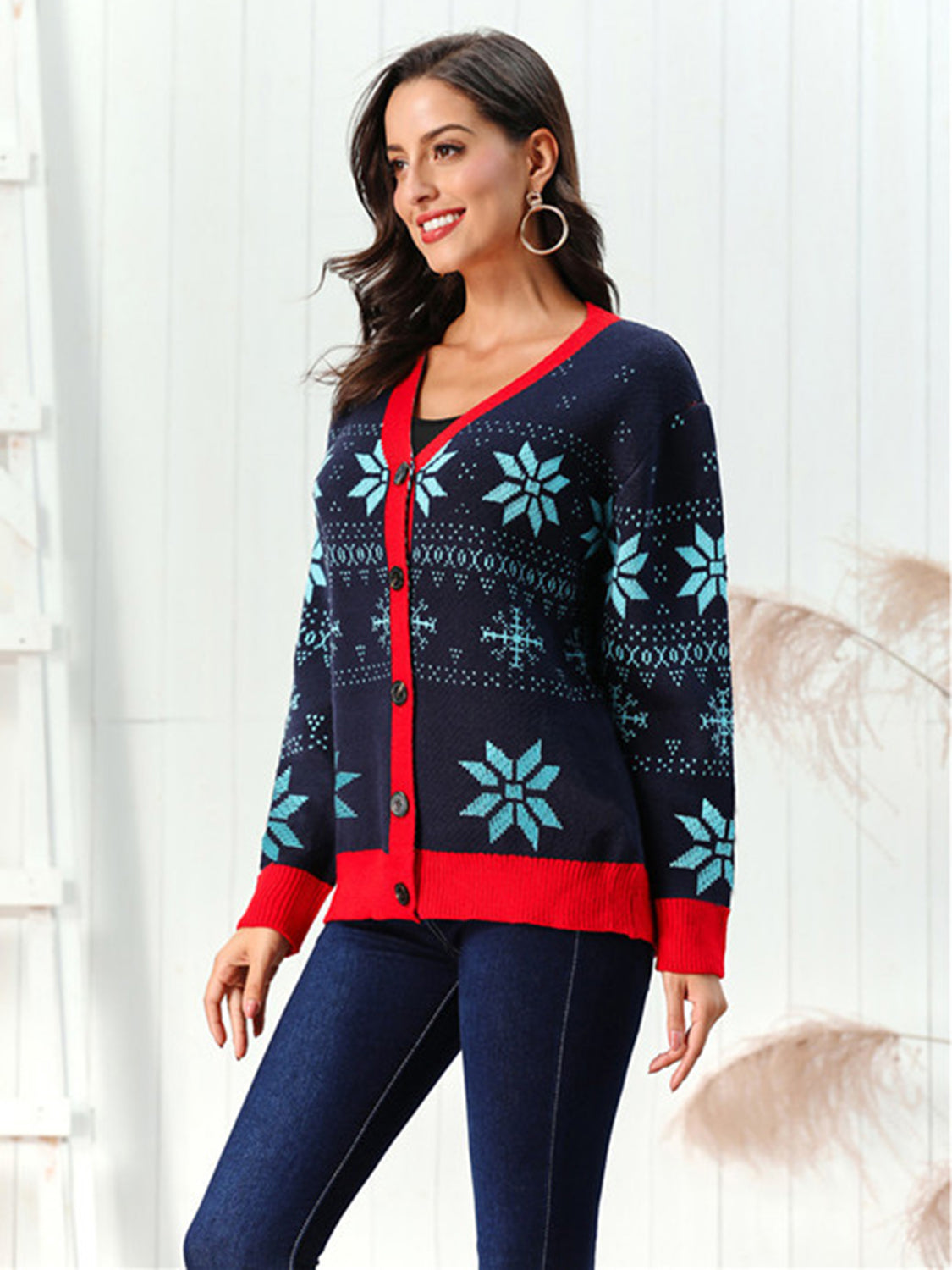 Dark blue acrylic cardigan with snowflake intarsia and red trim.