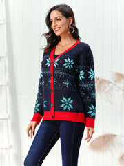 Dark blue acrylic cardigan with snowflake intarsia and red trim.