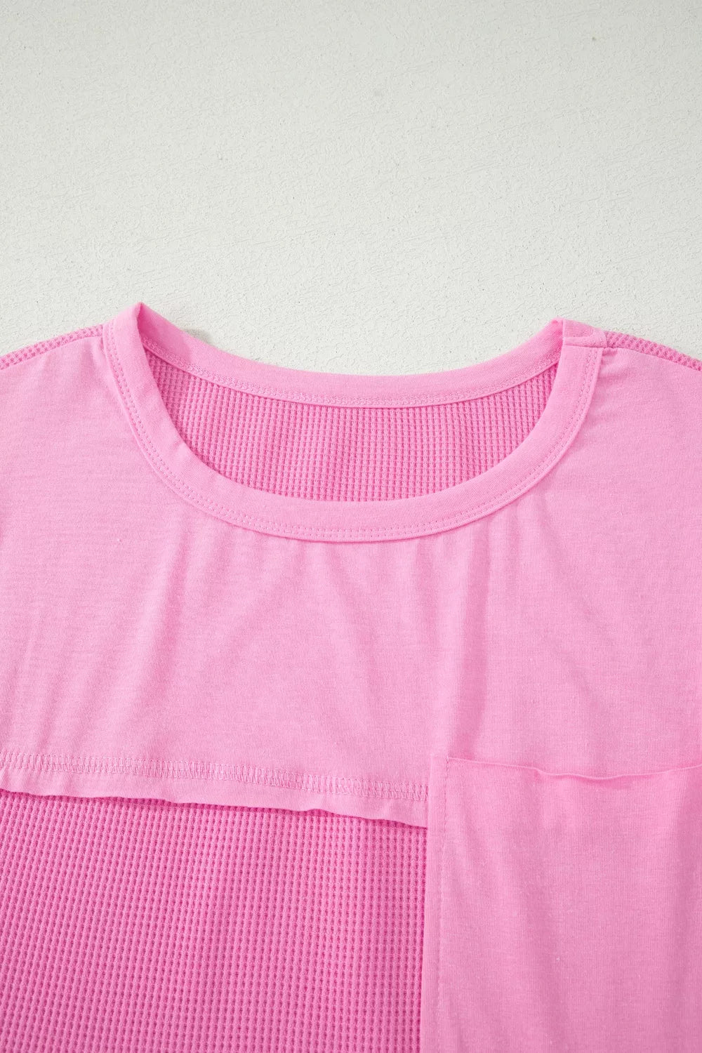 Pink waffled seam pocketed t-shirt with crew neck and short sleeves.