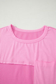 Pink waffled seam pocketed t-shirt with crew neck and short sleeves.