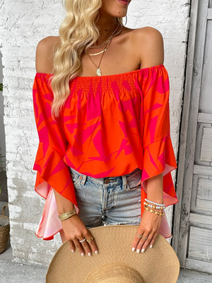 Off-shoulder orange blouse with geometric print and flared bell sleeves
