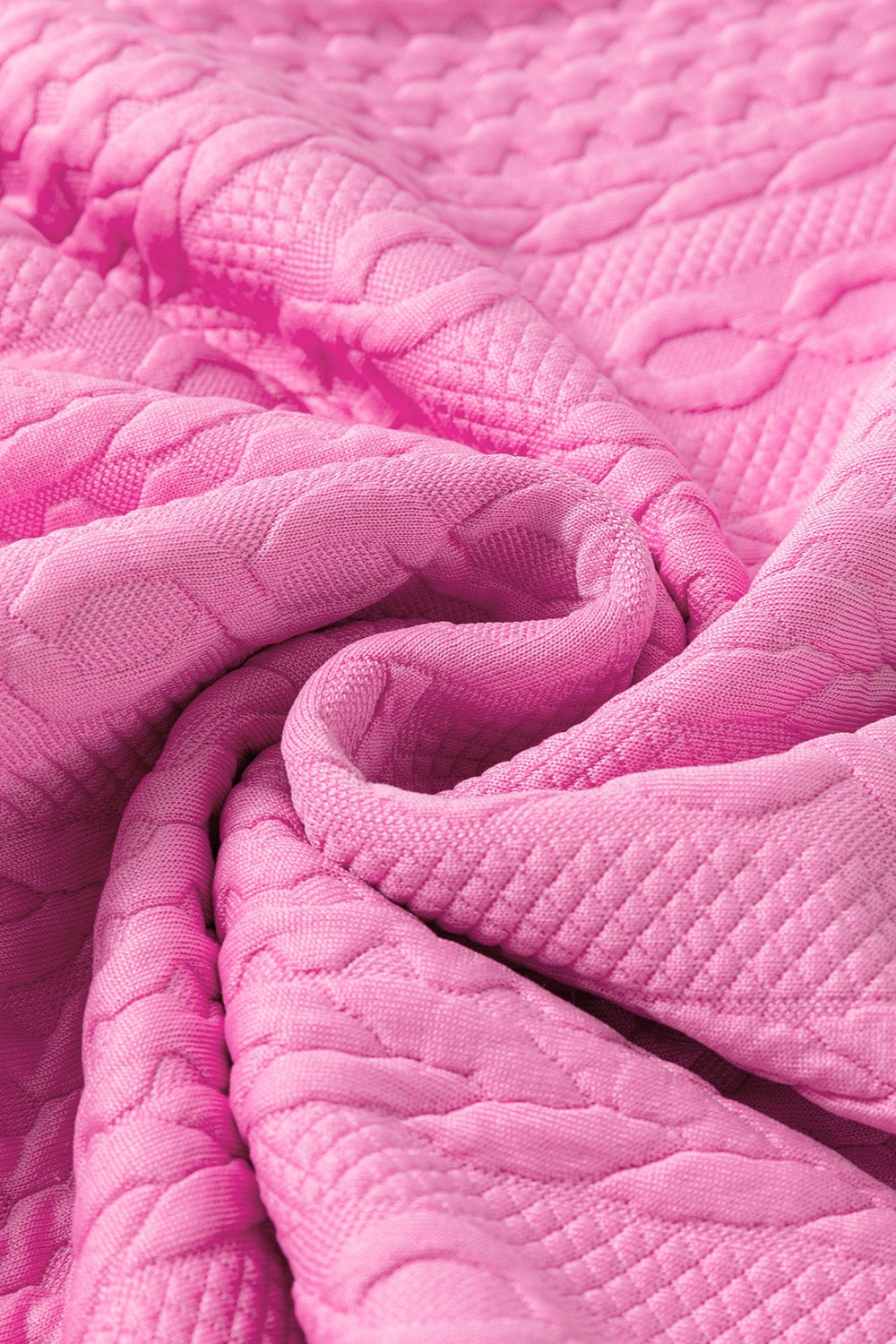 Pink textured knit loungewear fabric with cable knit pattern detail
