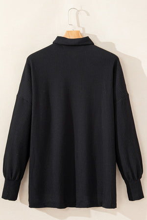 Black textured knit shirt jacket with collar and buttoned front, balloon sleeves.