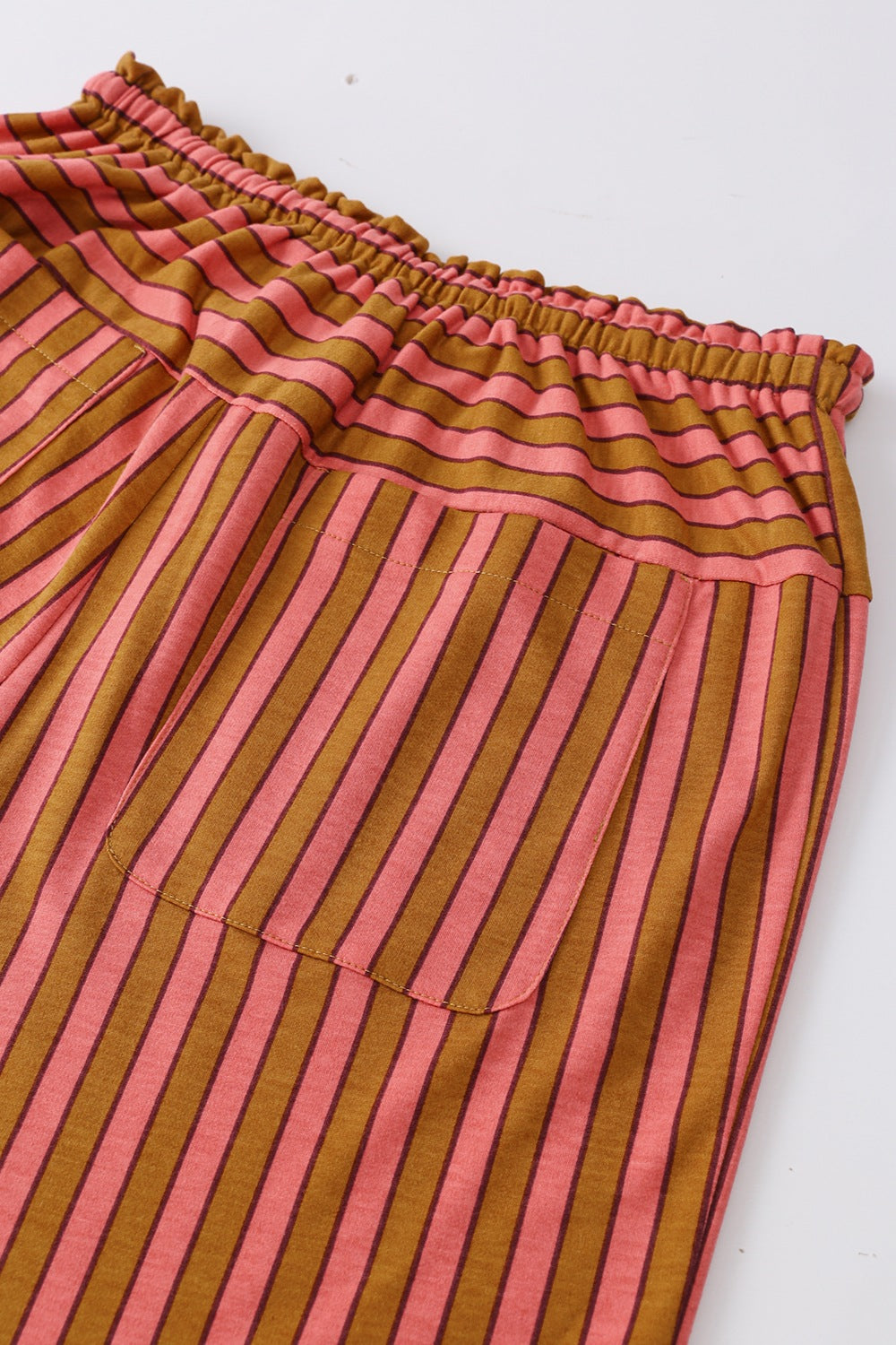 Wide leg drawstring pants in pink and brown stripes with functional pockets.