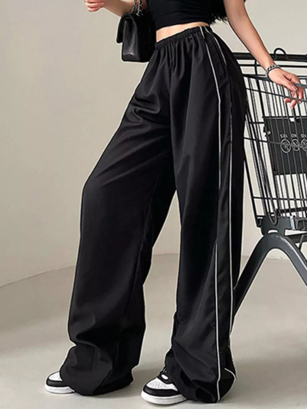 Black wide-leg maternity pants with gathered waistband and white side stripe detail.