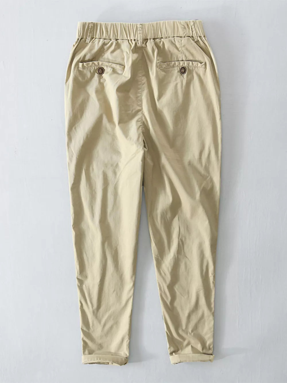 Khaki cargo pants with elastic waist, cuffed hem, and button-flap back pockets.