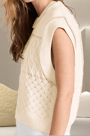 Ivory knit vest with cable and diamond patchwork patterns, crew neck, sleeveless.